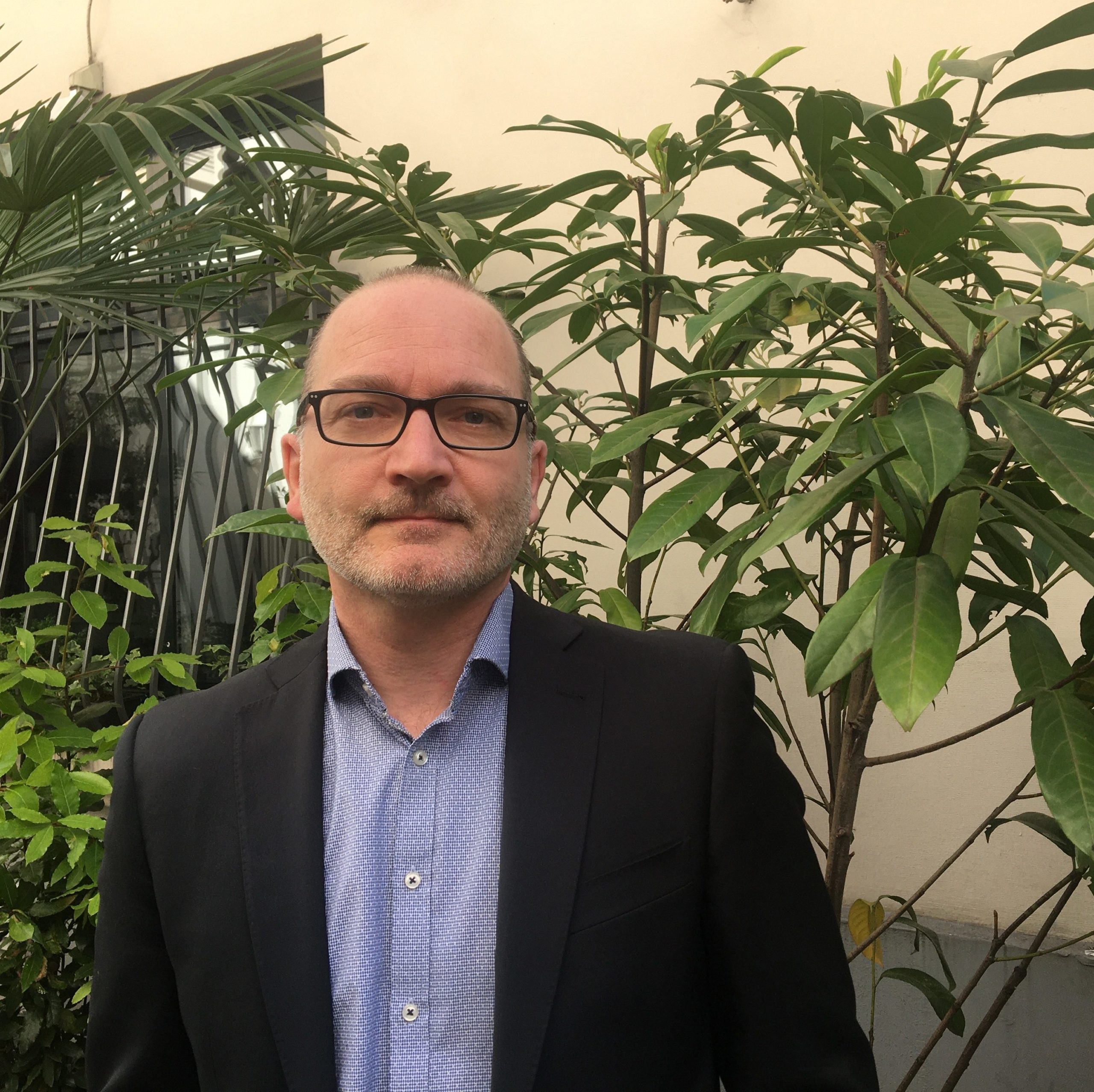 Photo de Daniel Perron devant des plantes vertes